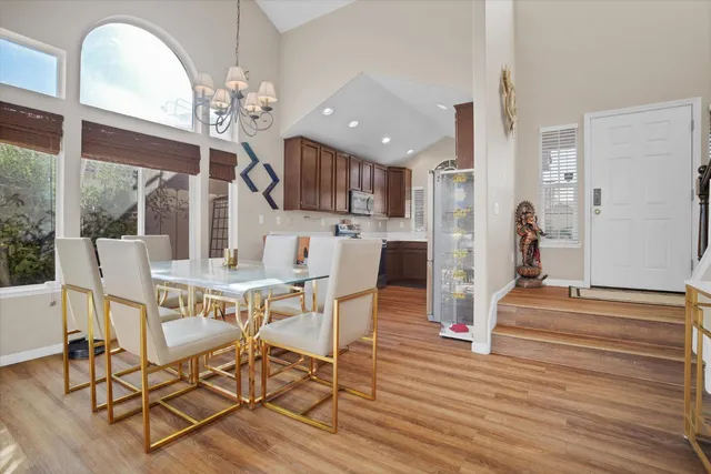 a view of a dining room with furniture a chandelier and wooden floor