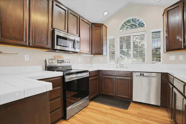 a kitchen with stainless steel appliances granite countertop a stove a sink and a microwave