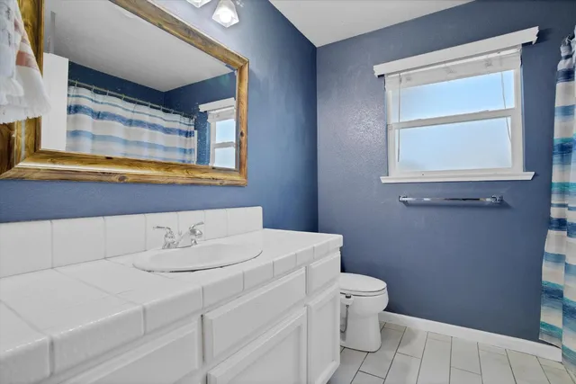 a bathroom with a sink a toilet and a window