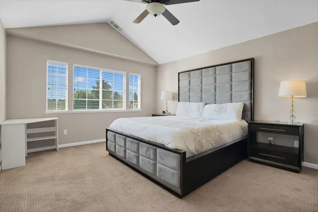 a large bed sitting in a room next to a window