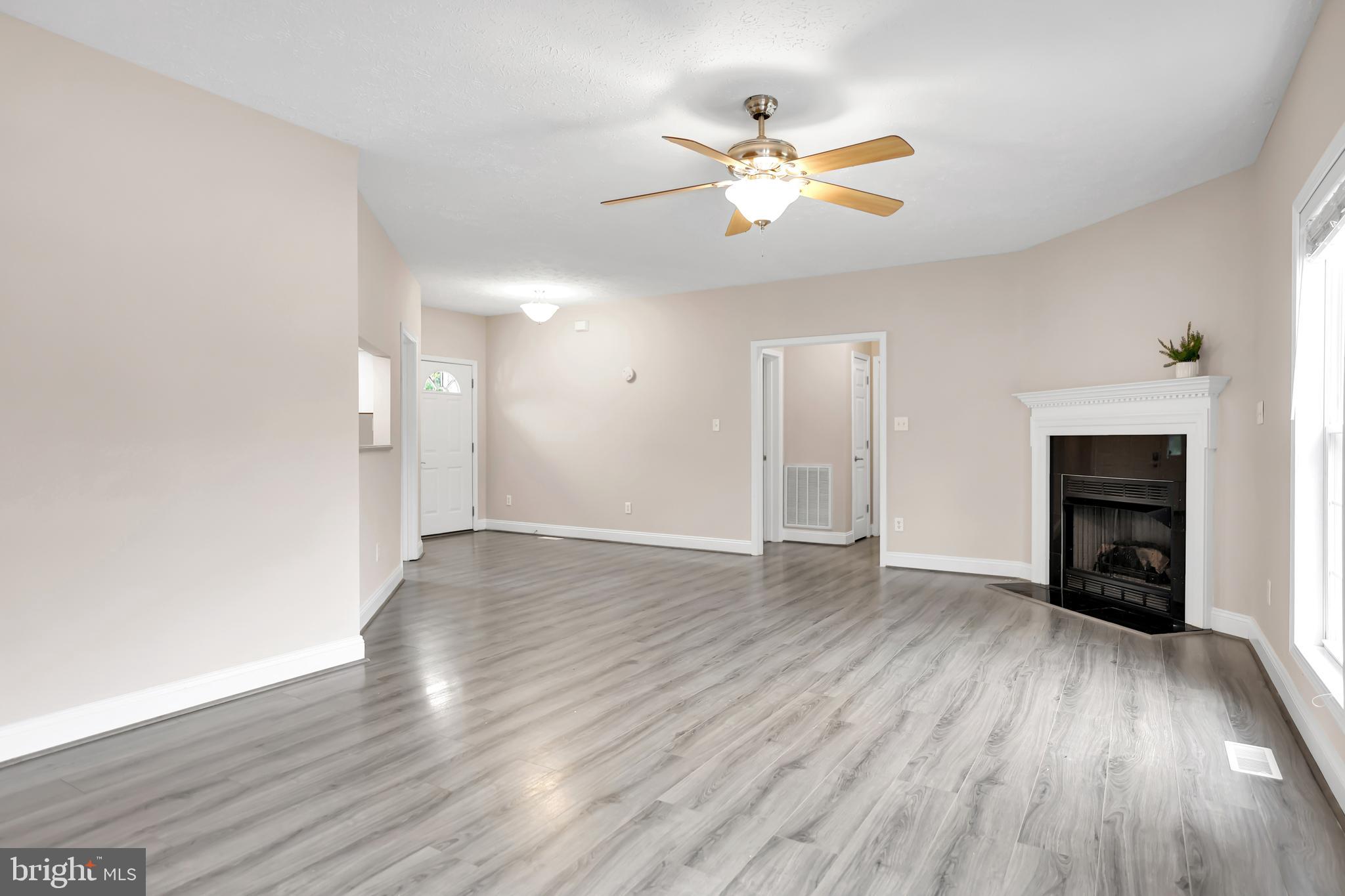 10717 Mt Sharon Road Orange, VA 22960 - Photo 12 of 35 an empty room with wooden floor chandelier fan and windows