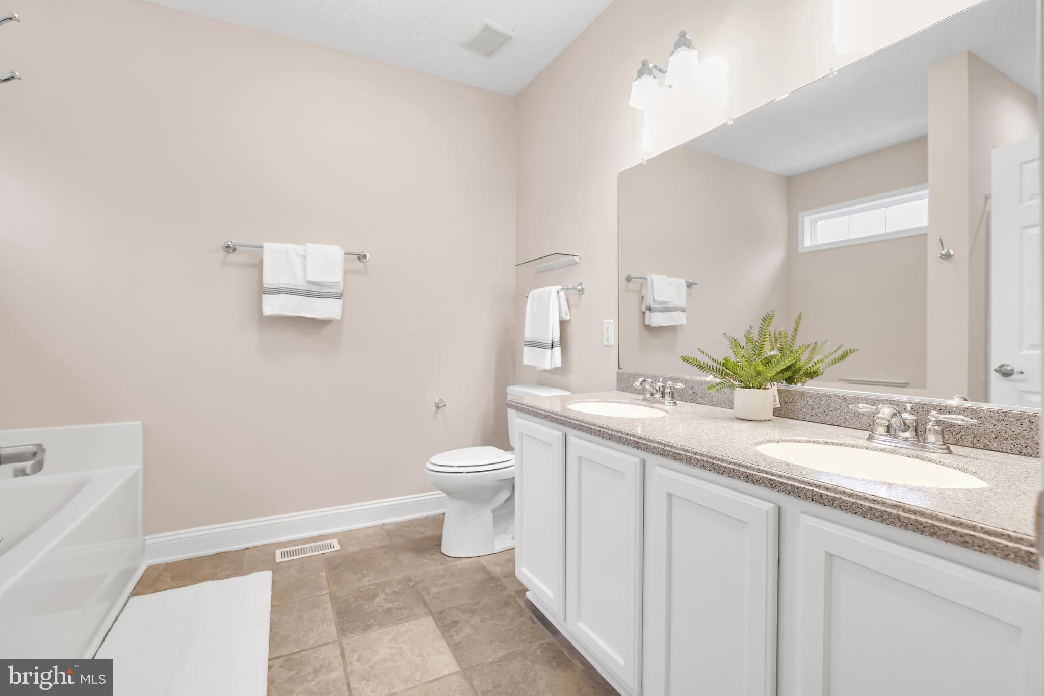 10717 Mt Sharon Road Orange, VA 22960 - Photo 21 of 35 a bathroom with a granite countertop sink a toilet and a mirror