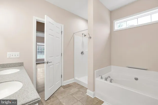 a bathroom with a tub a sink and a shower