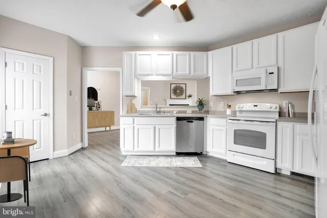 a kitchen with white cabinets and white appliances
