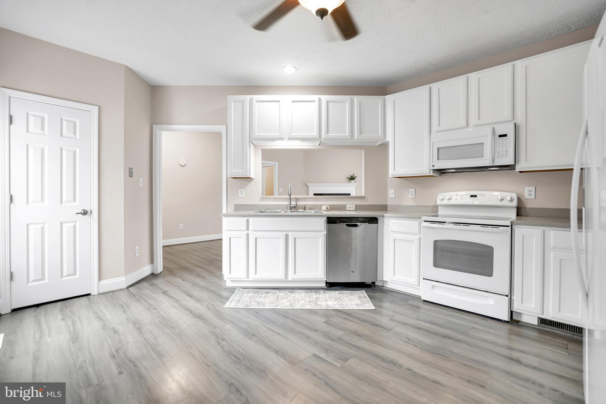 10717 Mt Sharon Road Orange, VA 22960 - Photo 9 of 35 a kitchen with a white cabinets and wooden floor