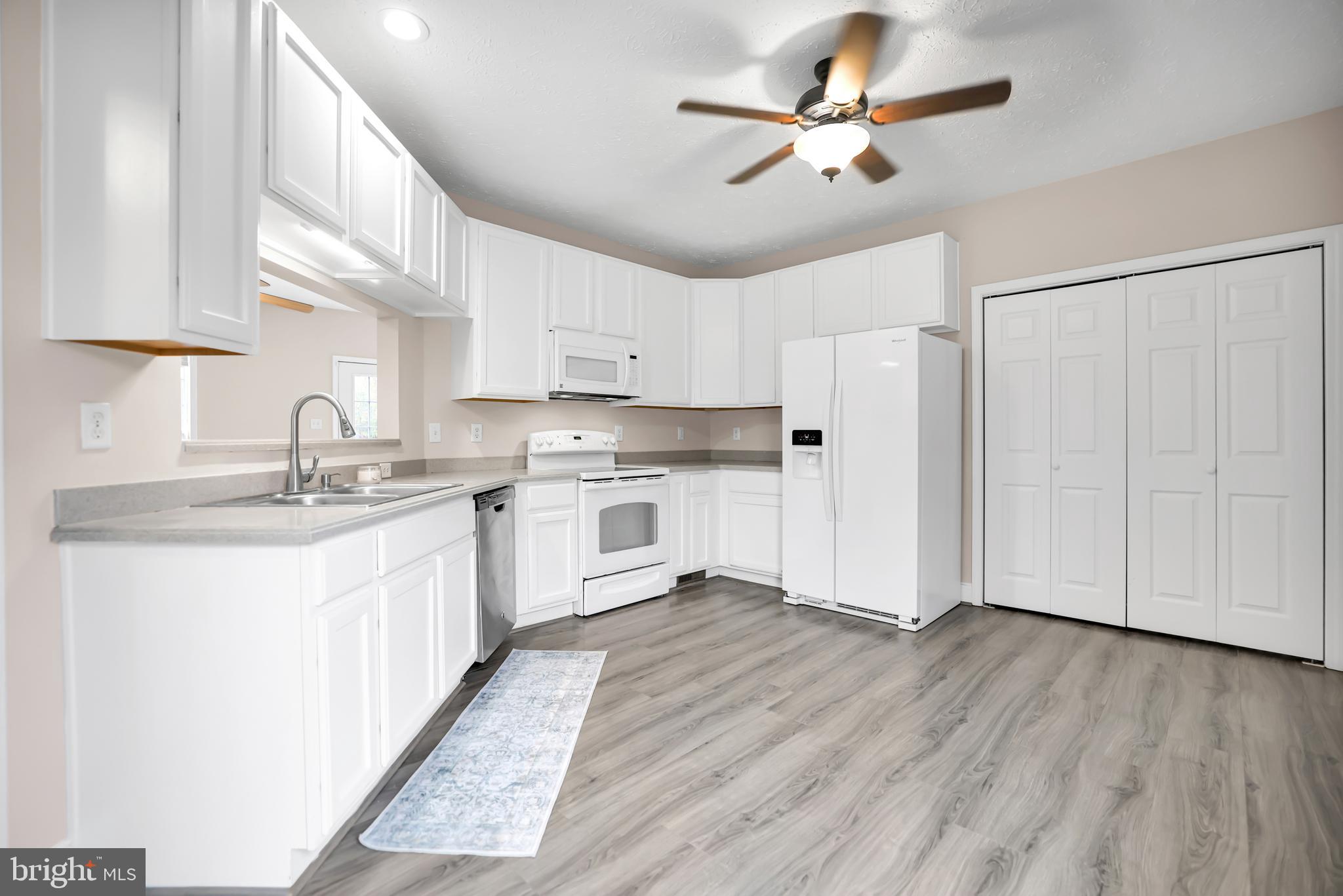 10717 Mt Sharon Road Orange, VA 22960 - Photo 10 of 35 a kitchen with white cabinets and white appliances
