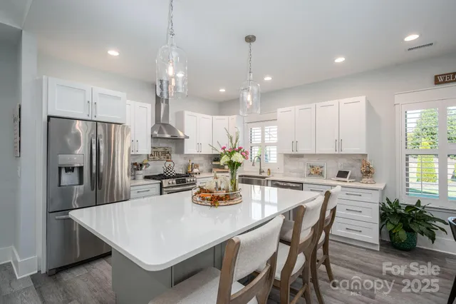 a kitchen with a dining table chairs refrigerator and microwave