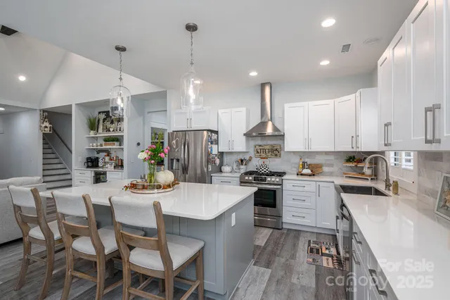 a kitchen with a dining table chairs wooden floor appliances and cabinets