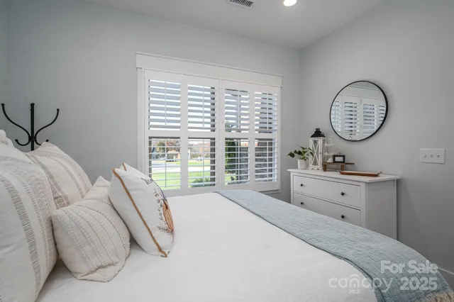 a spacious bedroom with a bed and a large window