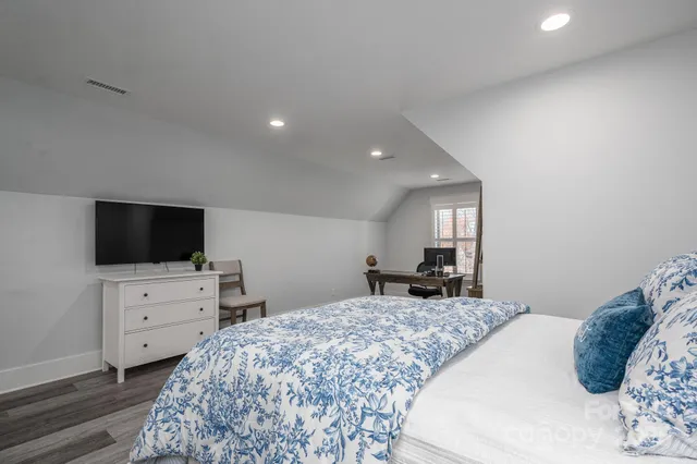 a bedroom with a bed and flat screen tv