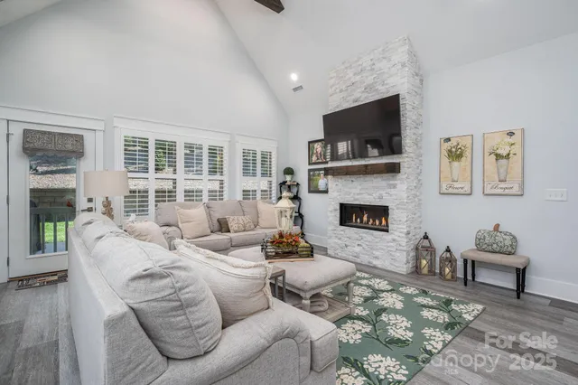 a living room with furniture a flat screen tv and a fireplace