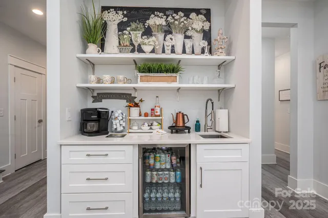 a kitchen with white cabinets and a wooden floor