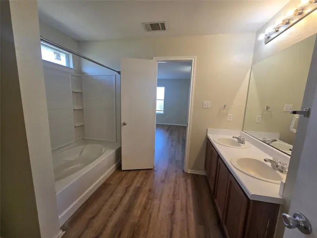a bathroom with a sink a mirror and a bathtub