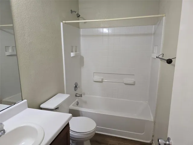 a white toilet sitting next to a bath tub