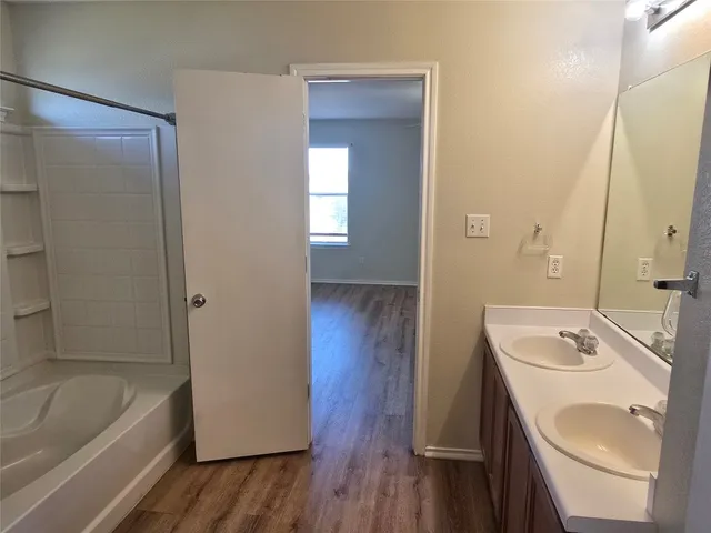 a bathroom with a tub sink and mirror
