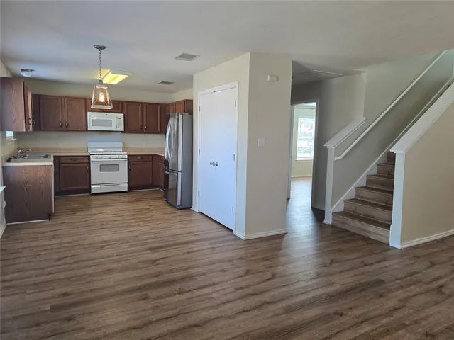 a view of a kitchen with cabinets and wooden floor
