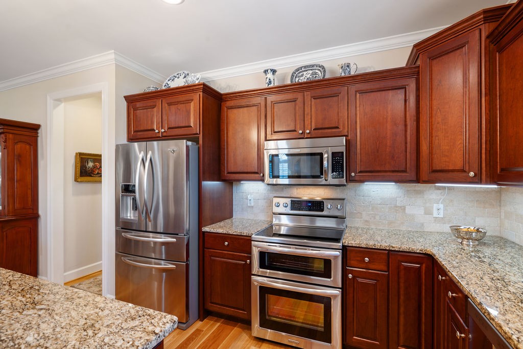 114 Hummingbird Lane Lawrenceburg, TN 38464 - Photo 11 of 38 a kitchen with granite countertop a refrigerator stove and microwave