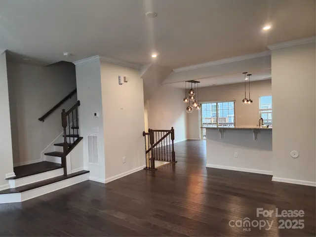 a view of a room with wooden floor and a kitchen