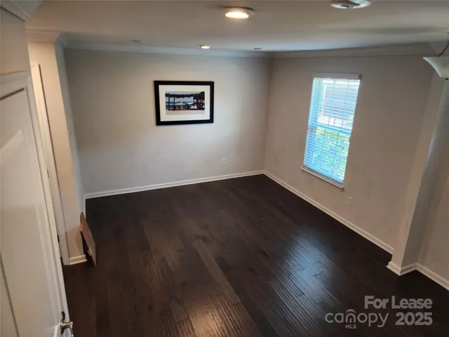 a view of a hallway with wooden floor and a window