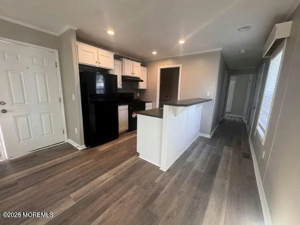 a view of kitchen with refrigerator microwave and stove with wooden floor
