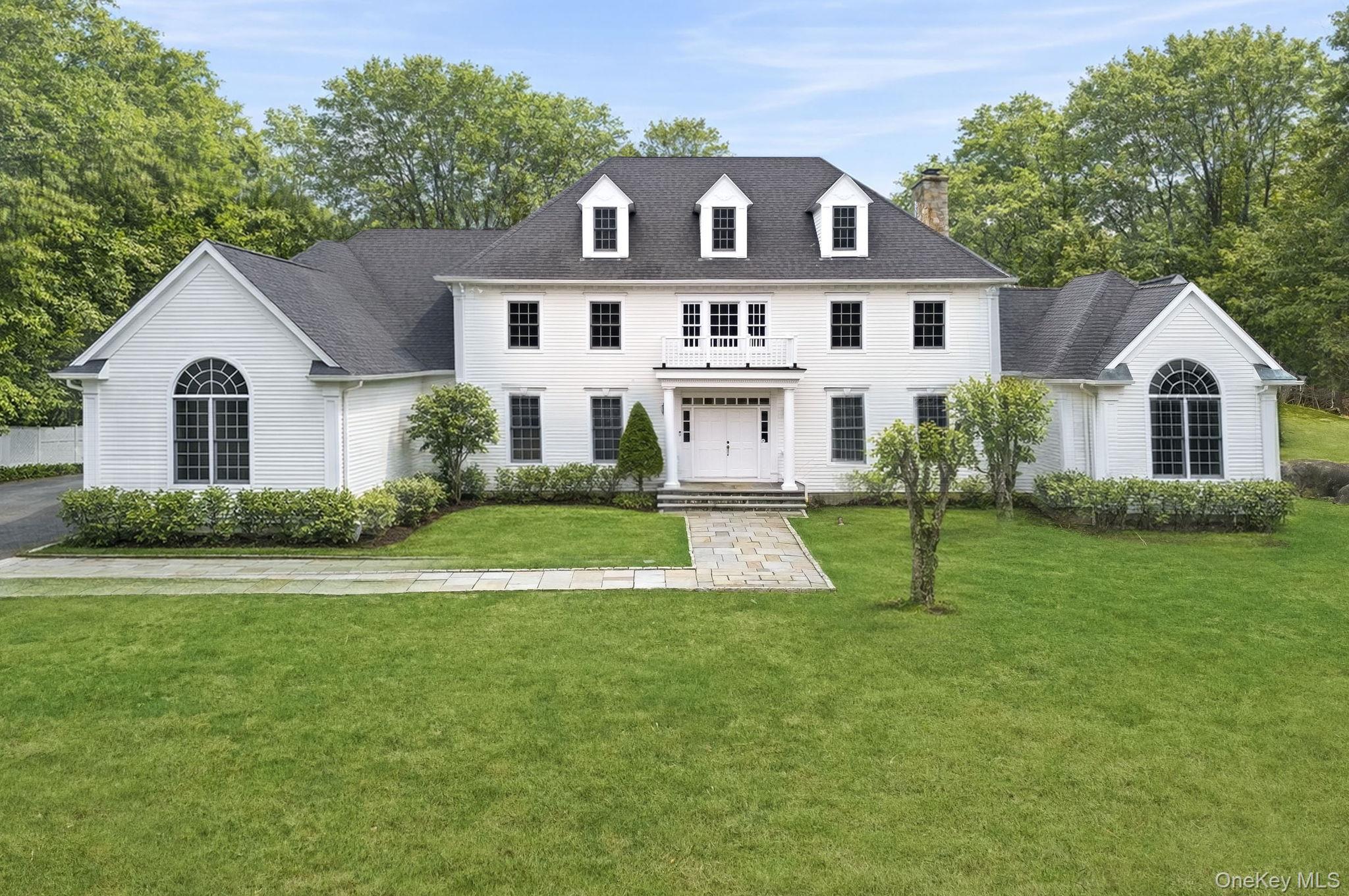 58 Old Logging Road Bedford, NY 10506 - Photo 2 of 34 a front view of a house with a yard and trees