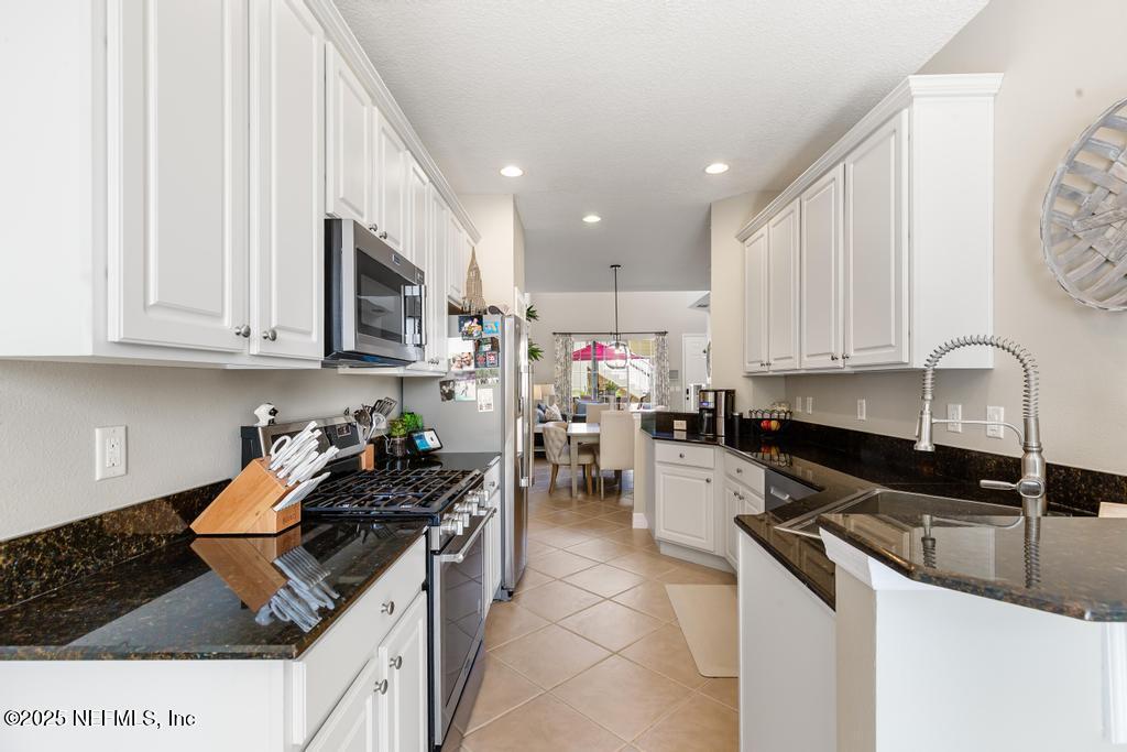 555 Hedgewood Drive St. Augustine, FL 32092 - Photo 11 of 70 a kitchen with granite countertop a sink a stove and cabinets