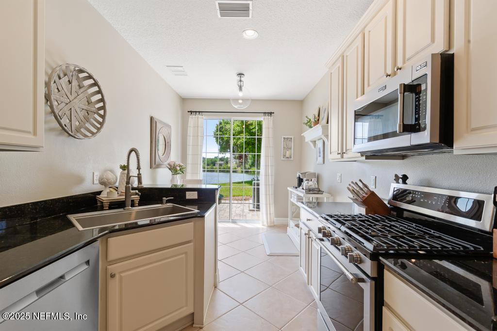 555 Hedgewood Drive St. Augustine, FL 32092 - Photo 13 of 70 a kitchen with a stove and a sink