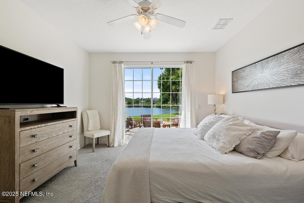 555 Hedgewood Drive St. Augustine, FL 32092 - Photo 17 of 70 a bedroom with a large bed and a flat tv screen on dresser
