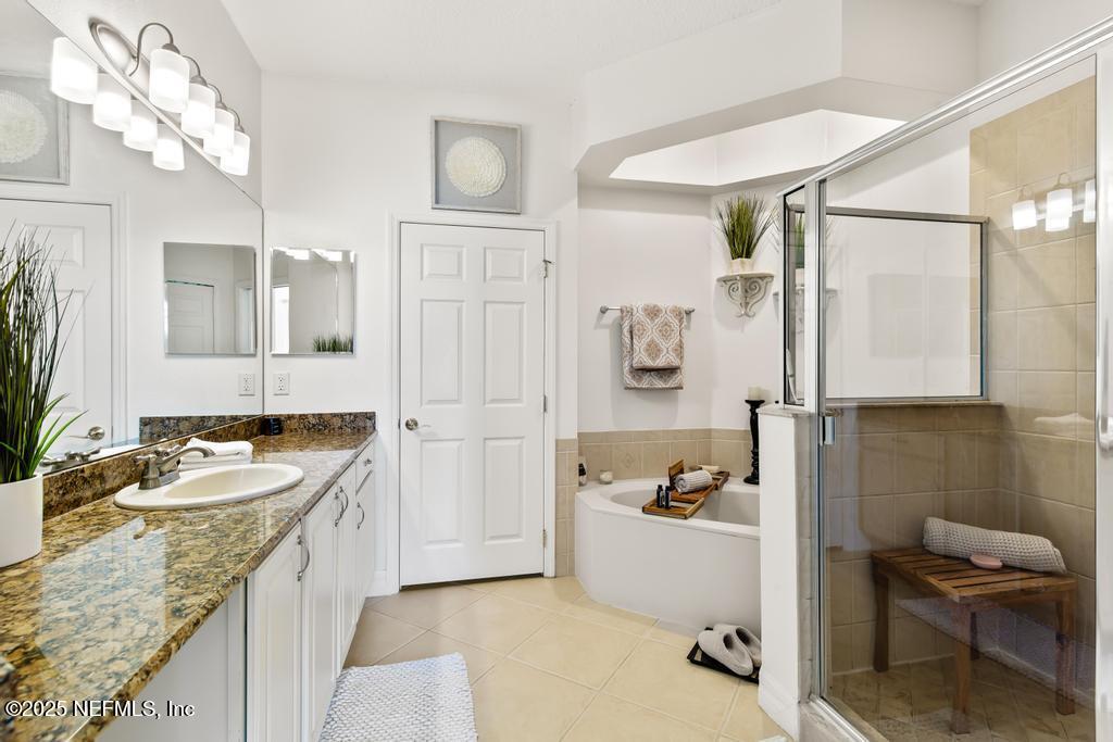 555 Hedgewood Drive St. Augustine, FL 32092 - Photo 18 of 70 a bathroom with a granite countertop tub sink and mirror