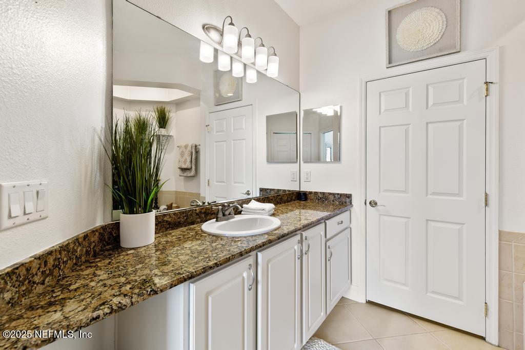 555 Hedgewood Drive St. Augustine, FL 32092 - Photo 19 of 70 a bathroom with a granite countertop sink and a mirror