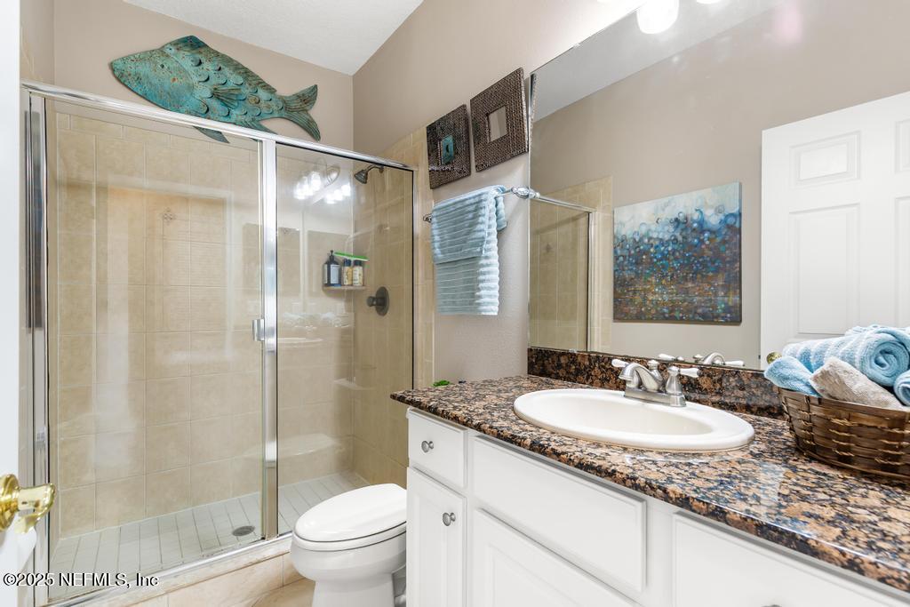 555 Hedgewood Drive St. Augustine, FL 32092 - Photo 28 of 70 a bathroom with a granite countertop sink toilet and shower