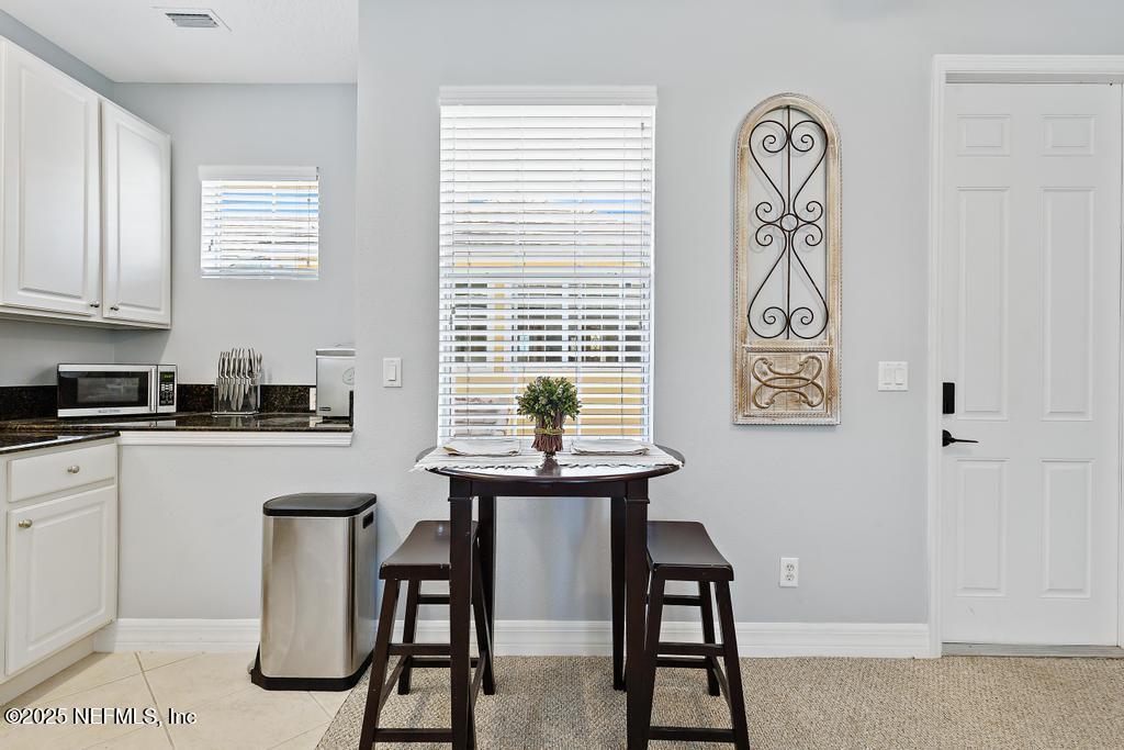 555 Hedgewood Drive St. Augustine, FL 32092 - Photo 43 of 70 a kitchen with stainless steel appliances a white table chairs and a window
