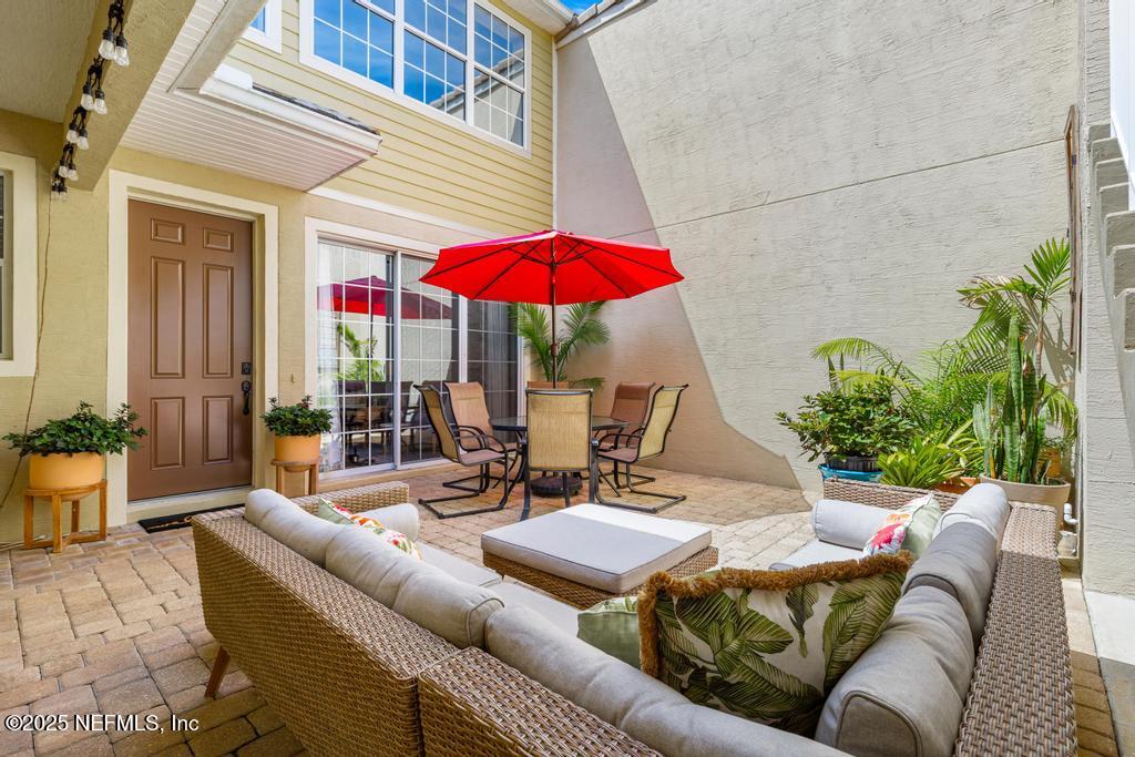 555 Hedgewood Drive St. Augustine, FL 32092 - Photo 5 of 70 a view of a patio with couches table and chairs under an umbrella