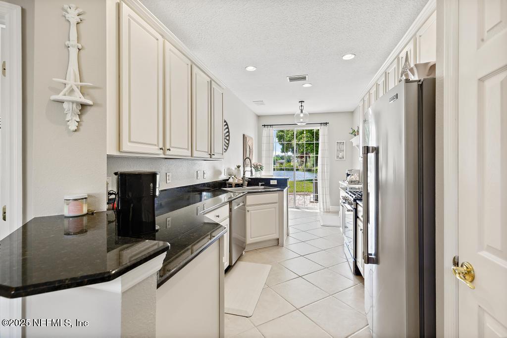 555 Hedgewood Drive St. Augustine, FL 32092 - Photo 10 of 70 a kitchen with stainless steel appliances granite countertop a sink refrigerator and cabinets