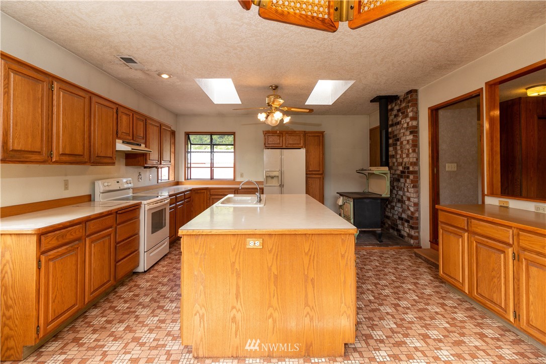 241 Cousins Road Chehalis, WA 98532 - Photo 7 of 27 a kitchen with a stove a sink a refrigerator and cabinets