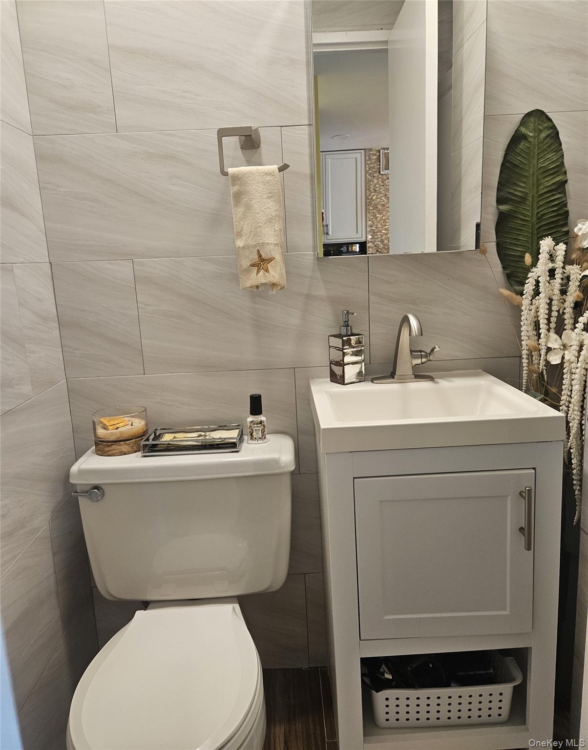 2 Richmond Road, Unit 4F Lido Beach, NY 11561 - Photo 5 of 26 Half bathroom with tile walls, vanity, and backsplash