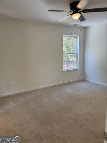 an empty room with a window and a fan
