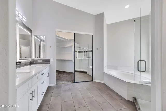 a bathroom with double vanity and a mirror