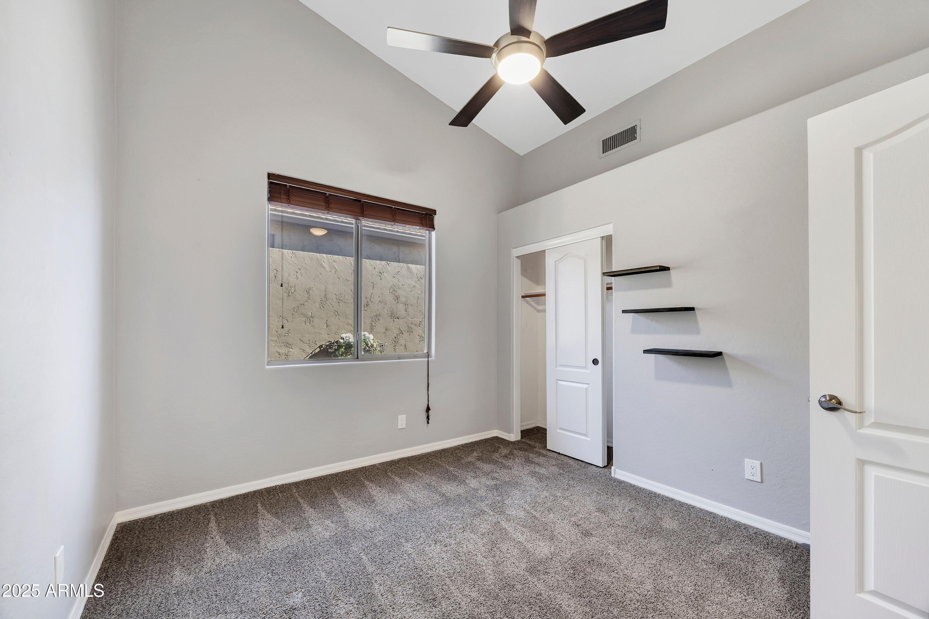 7446 East Glenn Moore Road Scottsdale, AZ 85255 - Photo 15 of 18 an empty room with a ceiling fan and a window