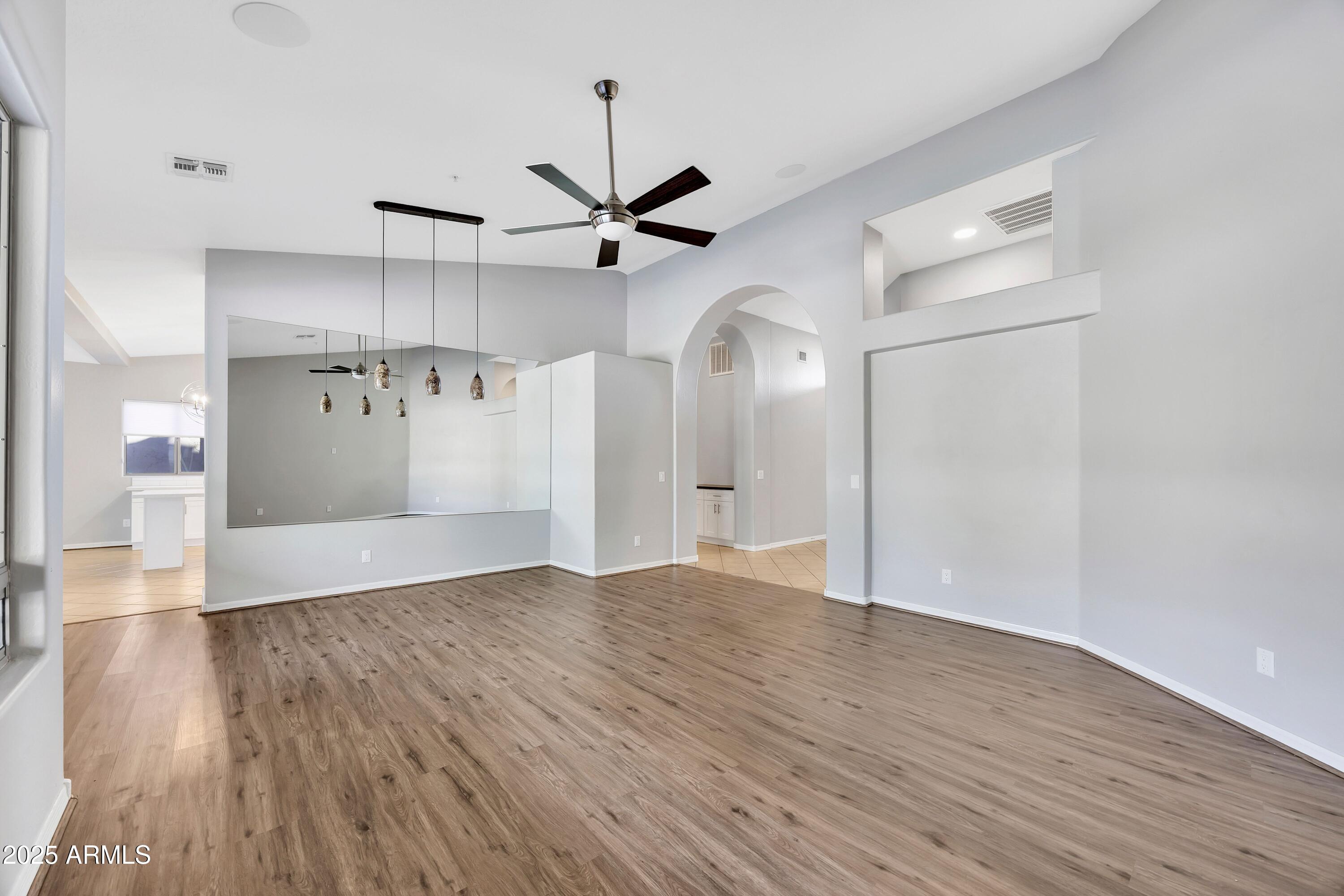 7446 East Glenn Moore Road Scottsdale, AZ 85255 - Photo 2 of 18 a view of an empty room with wooden floor and a ceiling fan