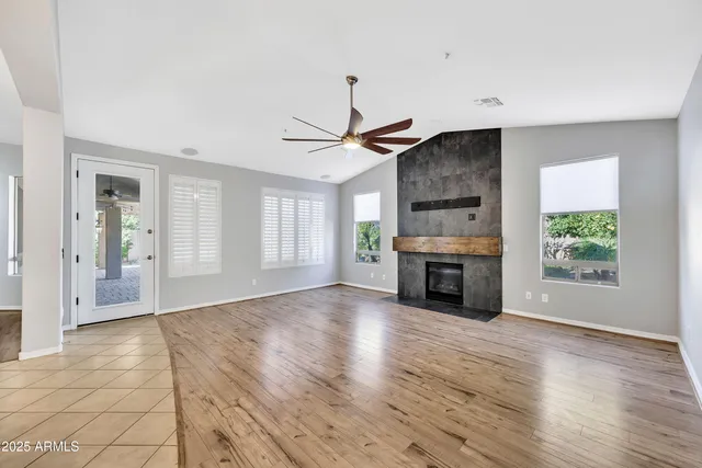 a view of empty room with kitchen and fireplace