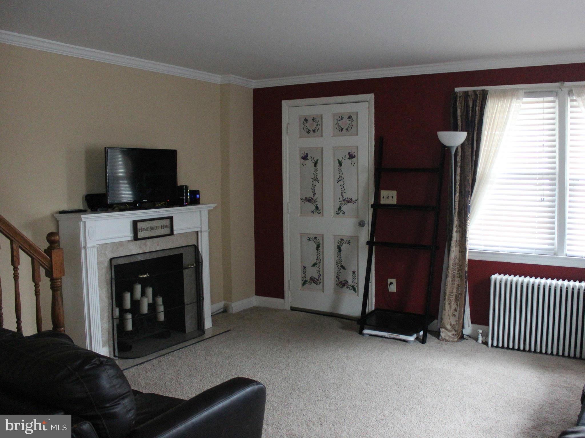 234 Arden Road West Baltimore, MD 21225 - Photo 8 of 26 a living room with furniture and a fireplace