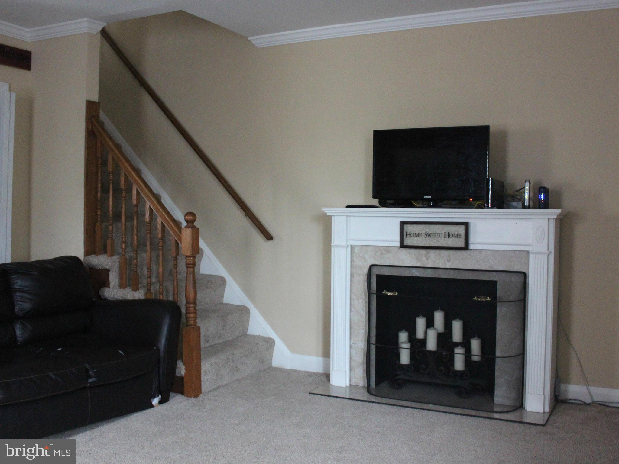 234 Arden Road West Baltimore, MD 21225 - Photo 9 of 26 a living room with a fireplace and a flat screen tv