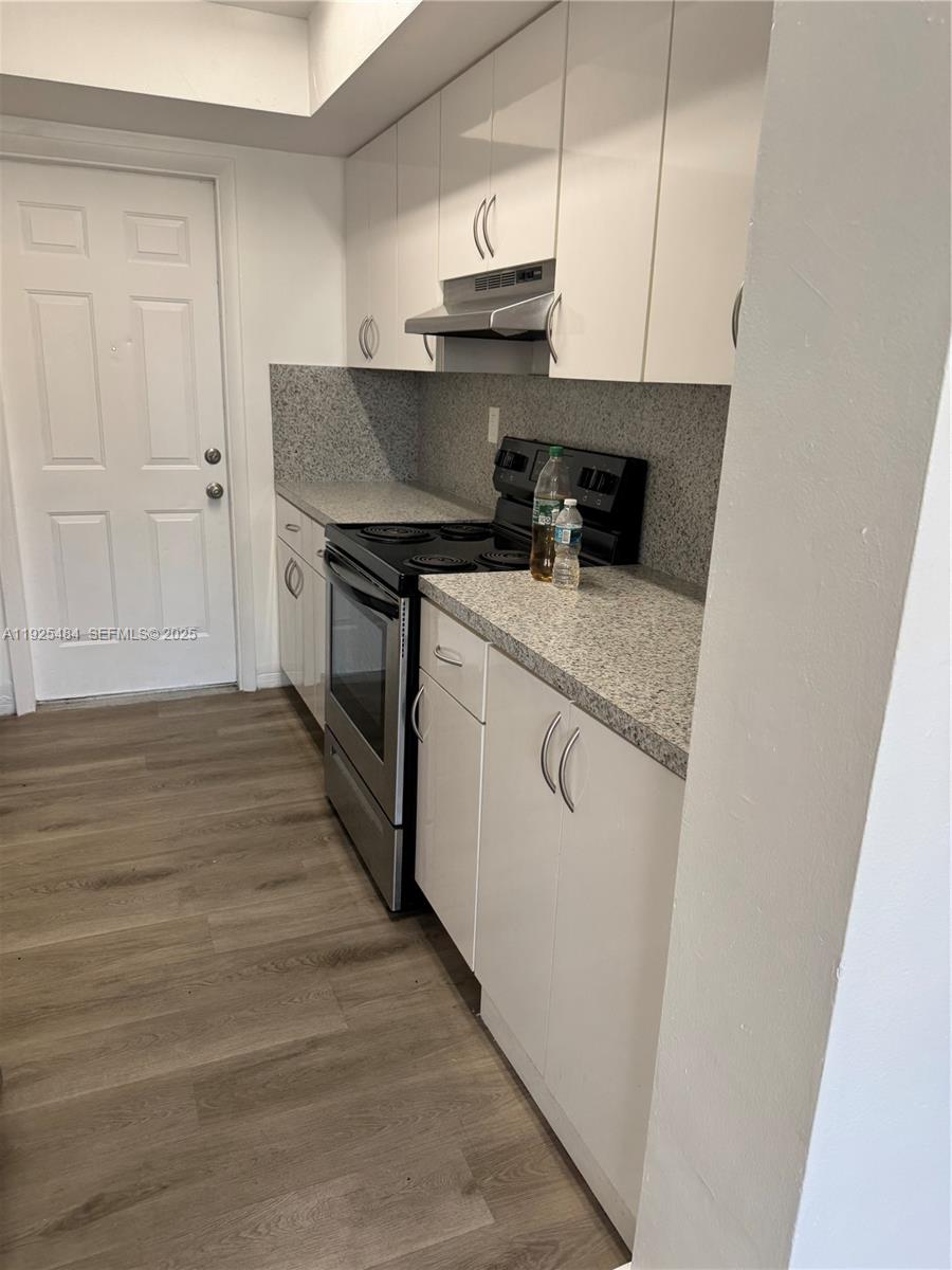 12175 Northeast 19th Avenue, Unit 2 North Miami, FL 33181 - Photo 2 of 6 a kitchen with stainless steel appliances granite countertop a stove a sink and a refrigerator