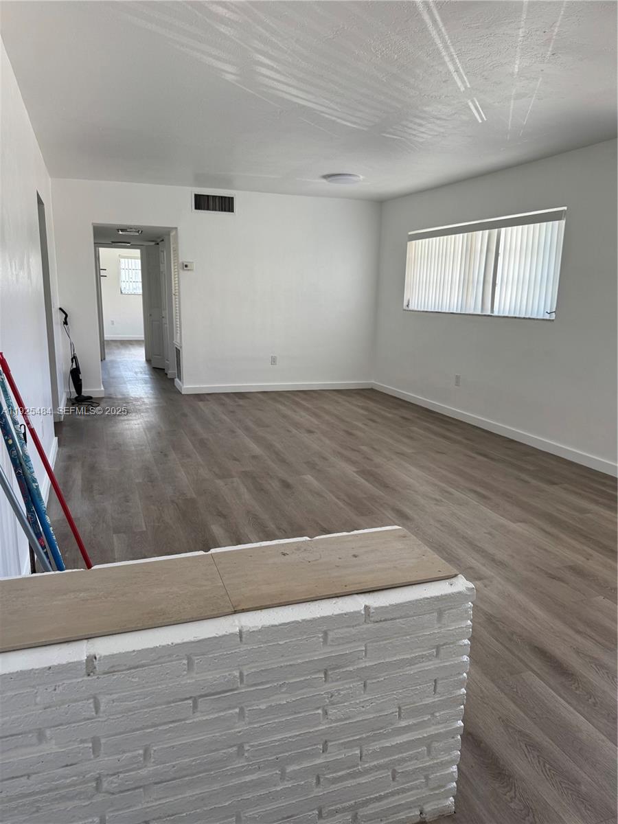 12175 Northeast 19th Avenue, Unit 2 North Miami, FL 33181 - Photo 4 of 6 an empty room with wooden floor and windows