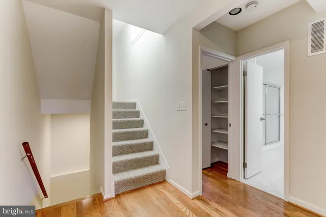 a view of a hallway with wooden floor and entryway