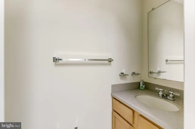 a bathroom with a granite countertop sink and a mirror