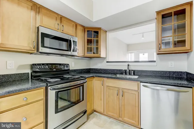 a kitchen with granite countertop white cabinets and appliances
