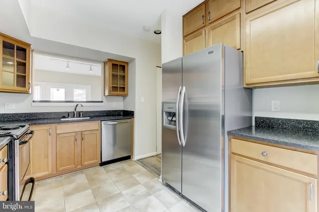 a kitchen with stainless steel appliances granite countertop a refrigerator and a stove