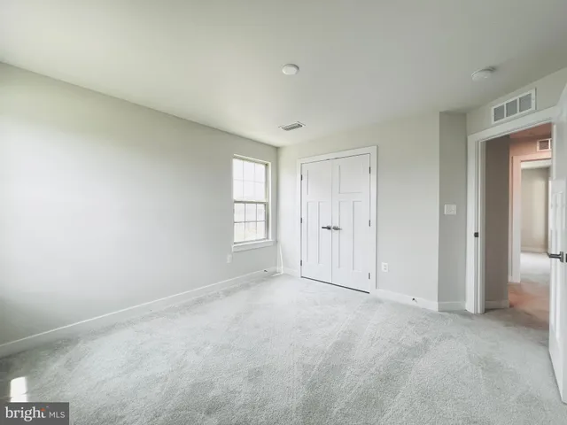 a spacious bedroom with a bed and a flat screen tv